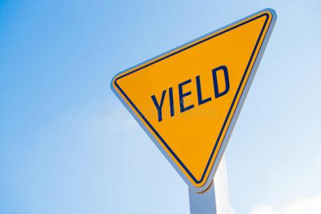 yellow-yield-sign-against-blue-sky-background-50802887