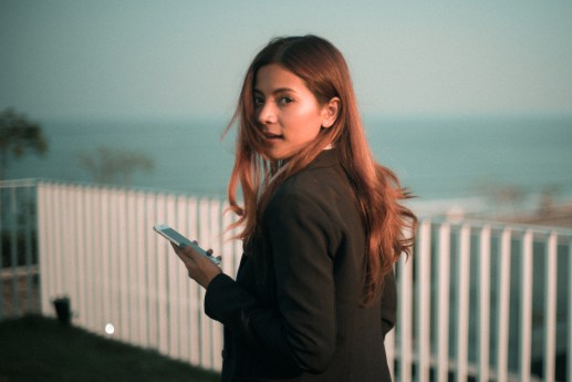 woman-looking-back-at-camera-holding-a-smartphone.jpg