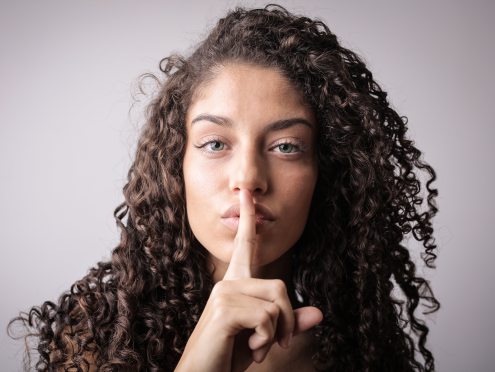 portrait-photo-of-woman-with-brown-curly-hair-doing-the-shhh-3764395